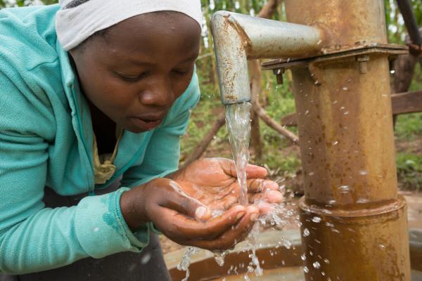 A girl catches water in her hands from a pump.PHOTO: Jake Lyell/Alamy