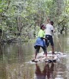 Hattie Payweyne, a seasoned CLTS professional with Liberia’s Ministry of Public Works, travels by raft in Grand Cape Mount County near the Sierra Leone border as part of a CLTS verification trip to monitor nearby communities’ progress in achieving open defecation-free status. Photo credit: Global Communities