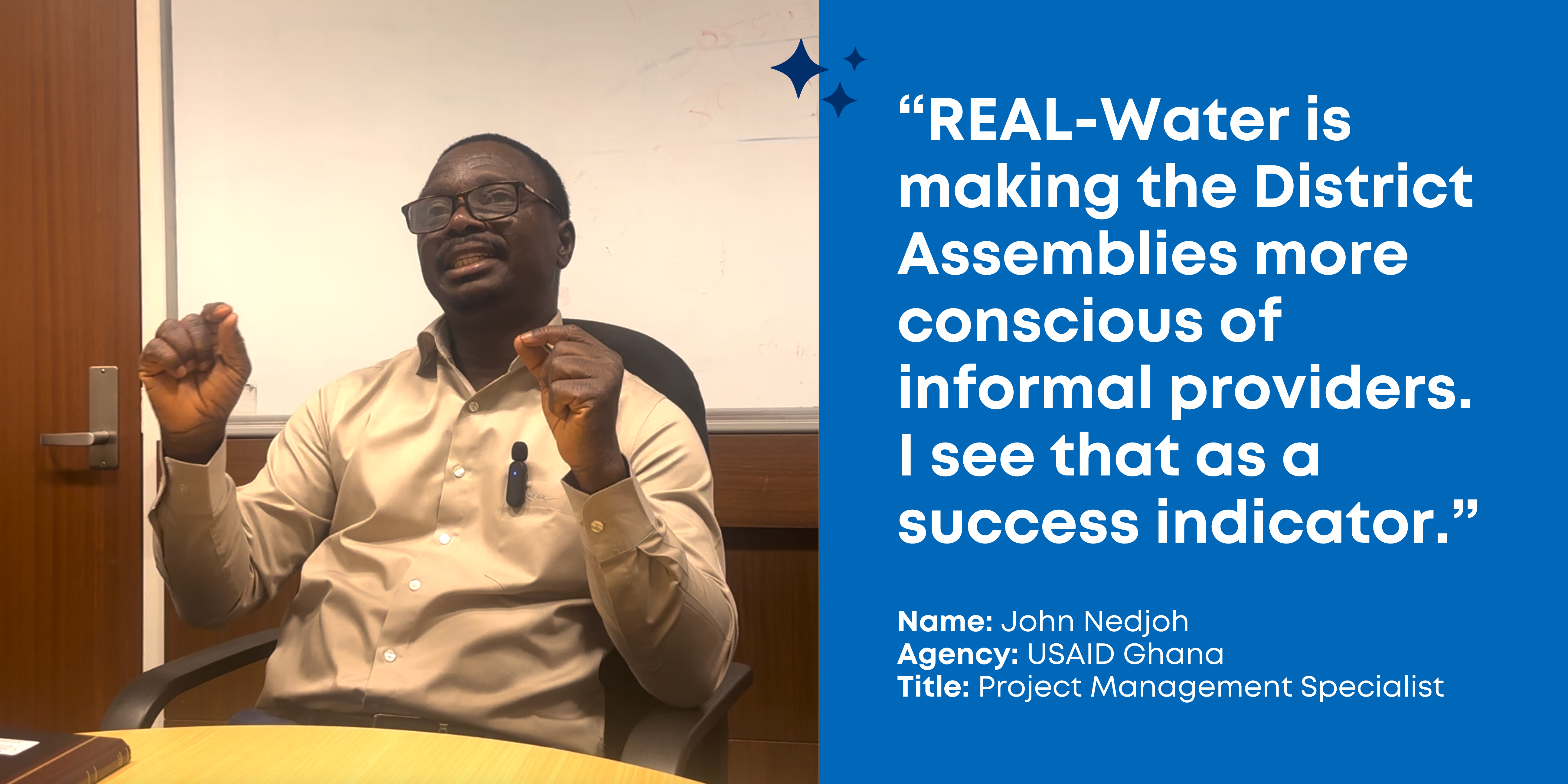 USAID Project Management Specialist, John Nedjoh, sits in an office chair wearing a beige collared shirt and gestures with his hands: "REAL-Water is making the District Assemblies more conscious of informal providers. I see that as a success indicator."