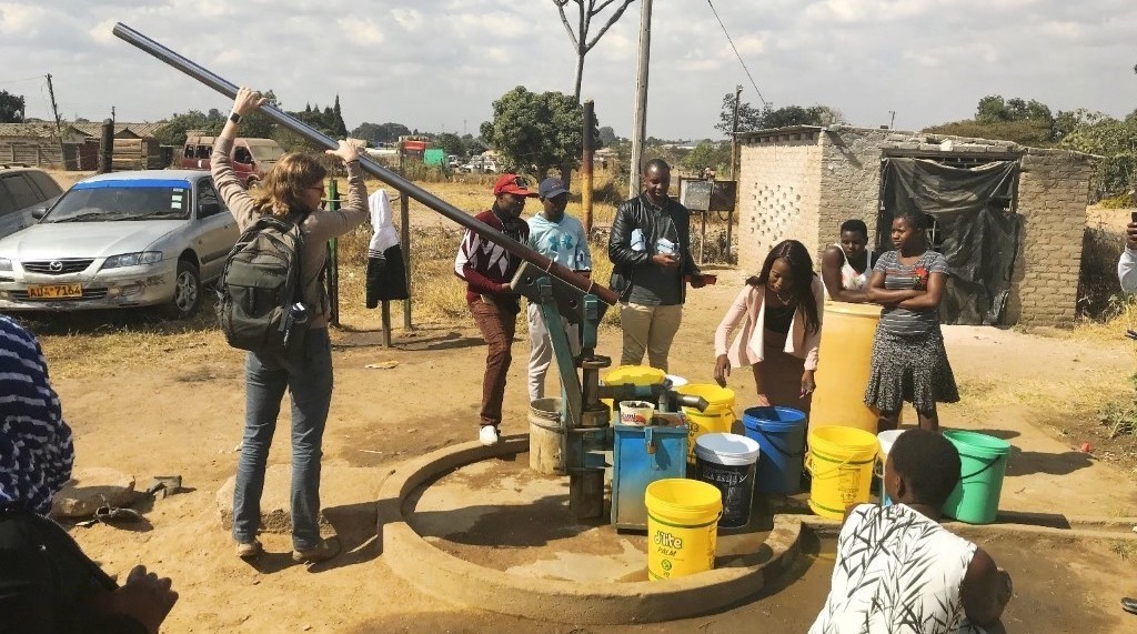 Andrea Martinsen of the CDC pumps water for a team of field staff who are testing free residual chlorine (FRC) at hands pumps fitted with inline chlorinators. Photo credit: CDC