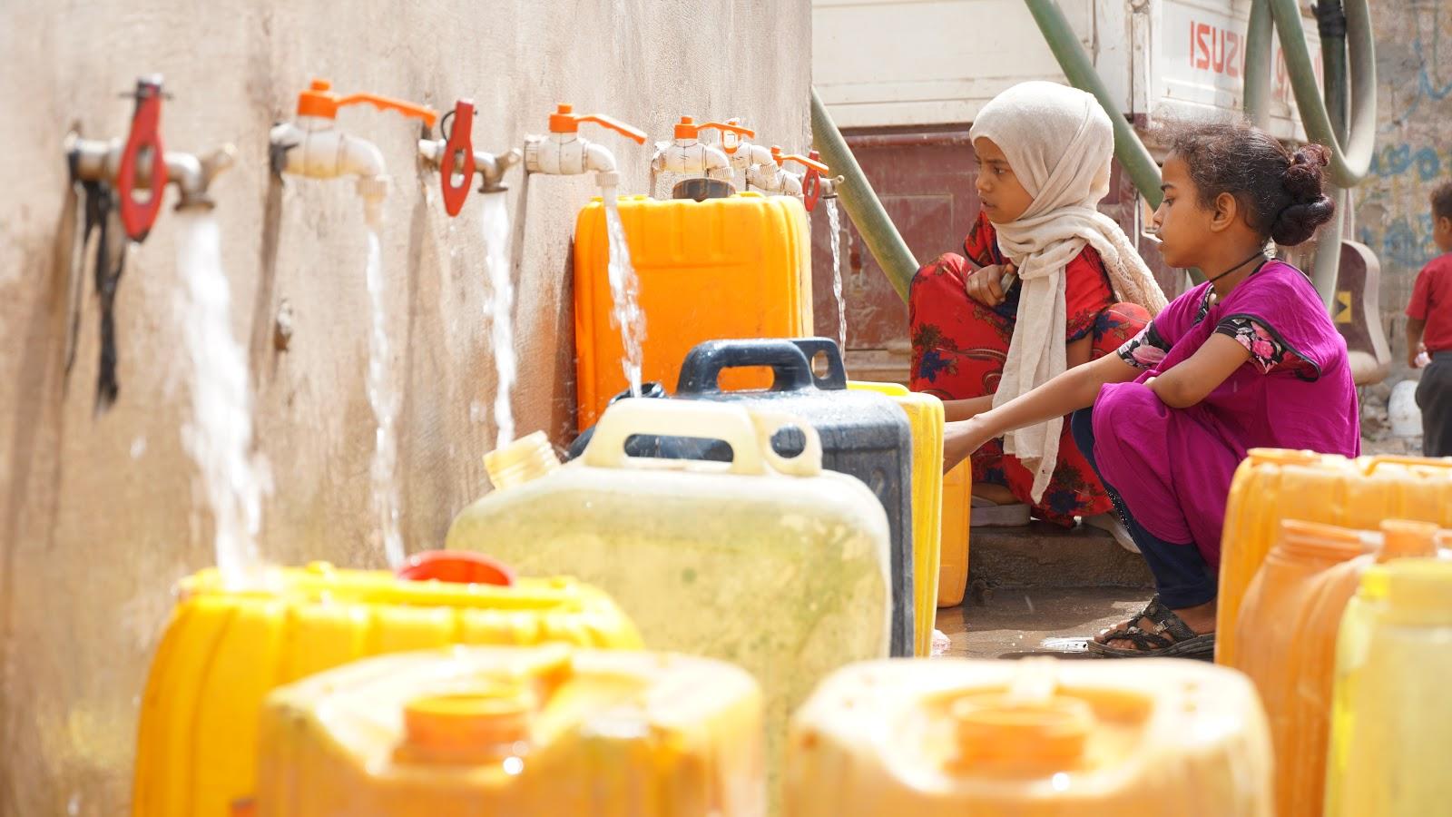 Two girls fill jerry cans at a water collection point built with USAID funding in the Jabal Habashy District of Ta’izz Governorate in Yemen. USAID funds construction and rehabilitation of water collection points closer to communities in Yemen. Photo Credit: CARE International