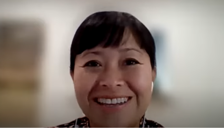  A screenshot of Nga Nguyen smiling. The background is blurred.