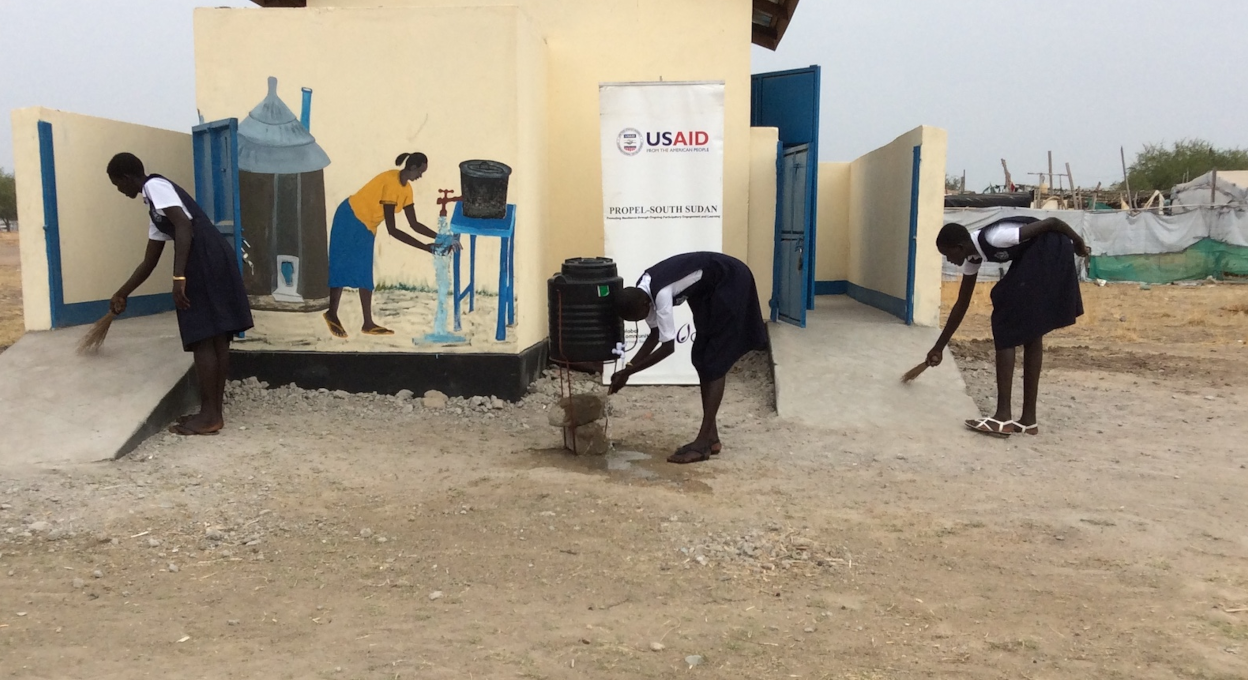 Hygiene Club members in Mingkaman, South Sudan, clean their new school latrine, which was built with support from USAID’s PROPEL project.   Credit: Global Communities