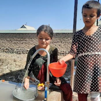 Children fill water from Ms. Sonia Rajabova’s self-constructed water stand. May, 2022. Credit: USAID/Tajikistan