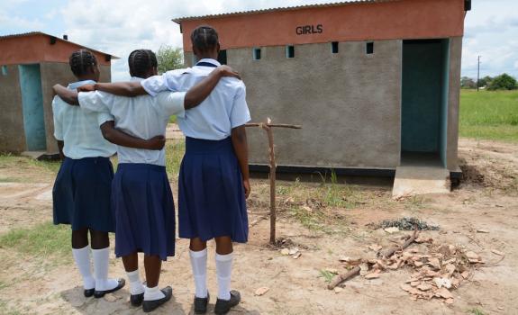 Schools in Zambia wait at the latrine. Photo credit: USAID/Zambia