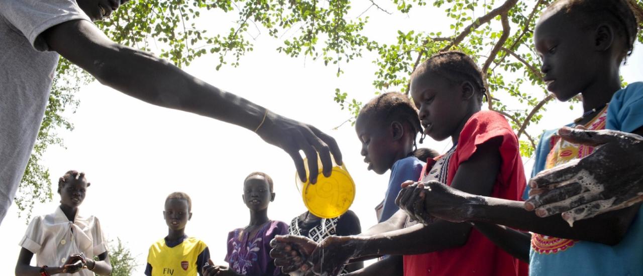  Children in Kuach, South Sudan, learn how to wash their hands properly. USAID and its partners help communities form Care Groups to teach them about essential hygiene and health behavior to prevent diseases like cholera and diarrhea. Photo credit: UNICEF/Kate Holt