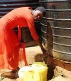 A young lady collects water from a water kiosk in Busia town. Photo credit: USAID/KIWASH