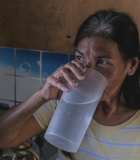Woman sips a cup of clean water